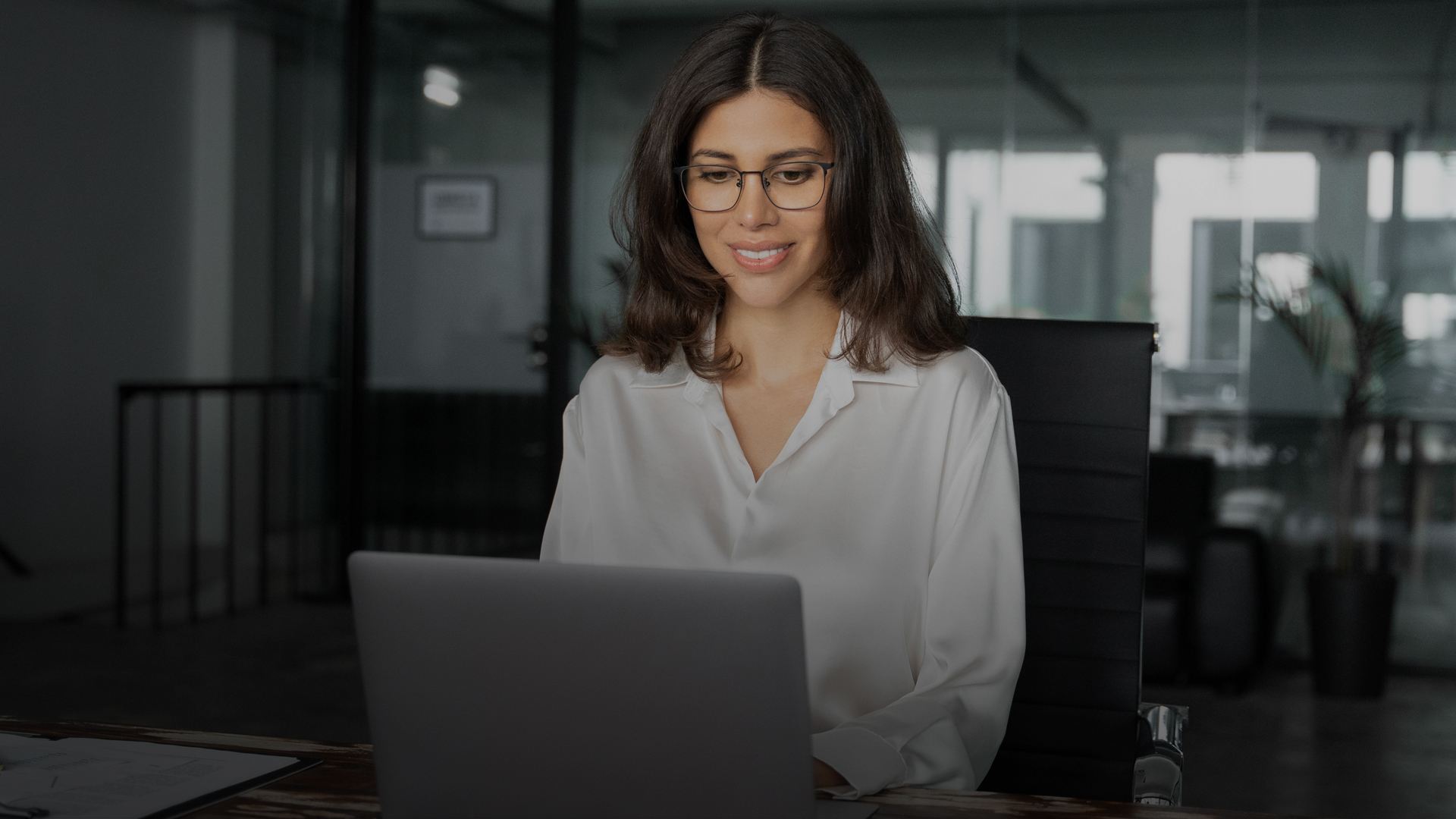 Professional working on a laptop in a modern office environment, focusing on digital transformation and technology solutions.