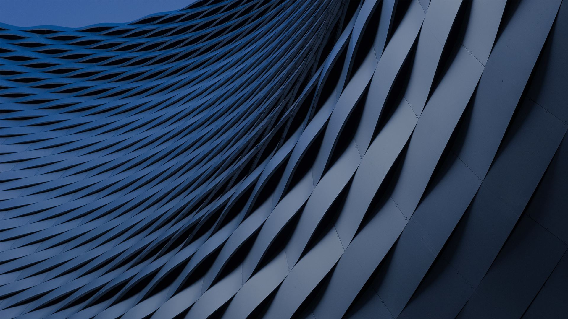 The banner features an abstract architectural design with a series of wavy, overlapping, and interwoven geometric patterns in shaded of blue, creating a dynamic and futuristic effect.