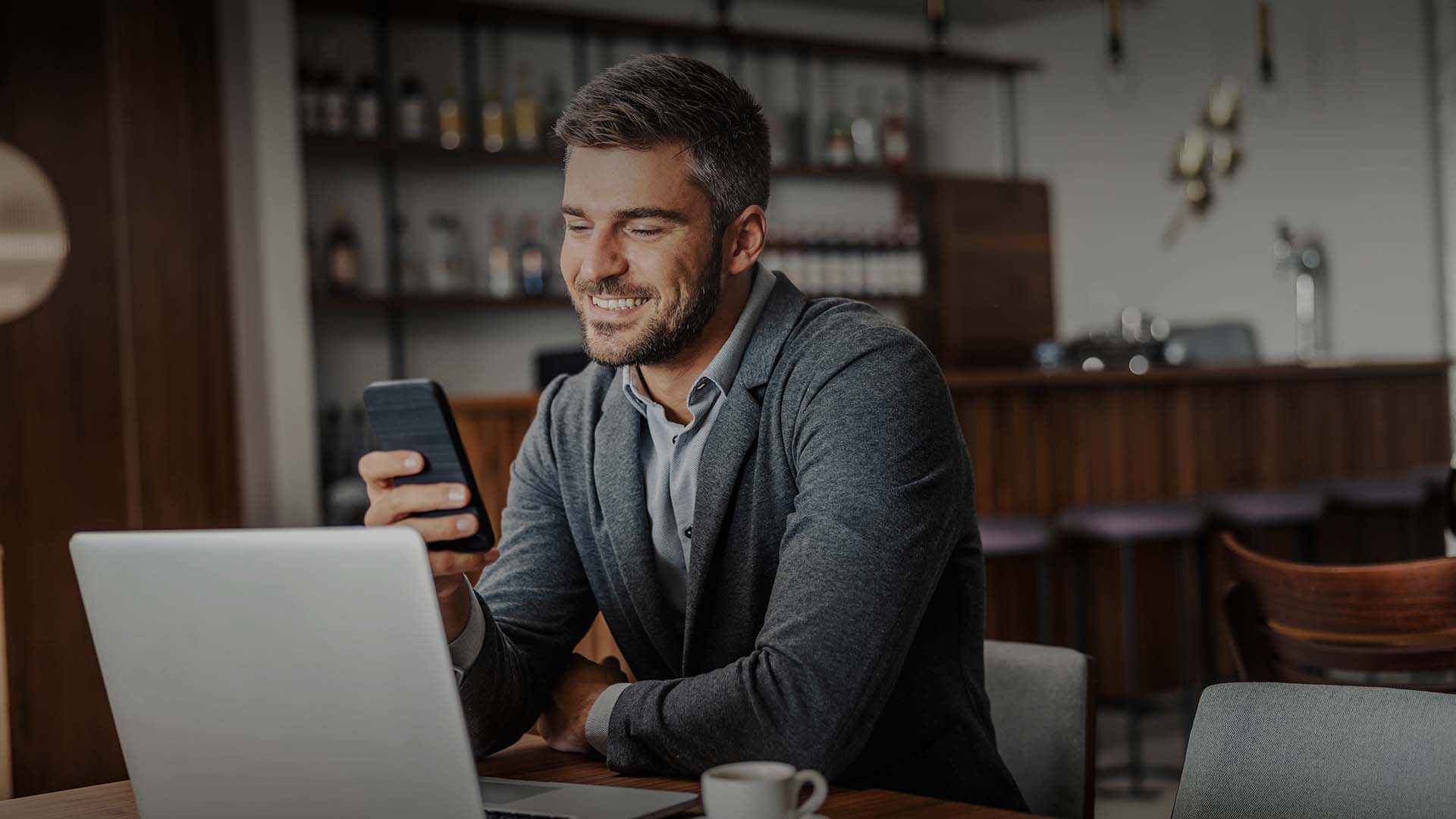 A professional sits at his desk and smiles as he uses Hexaware’s simple GCC readiness checklist.