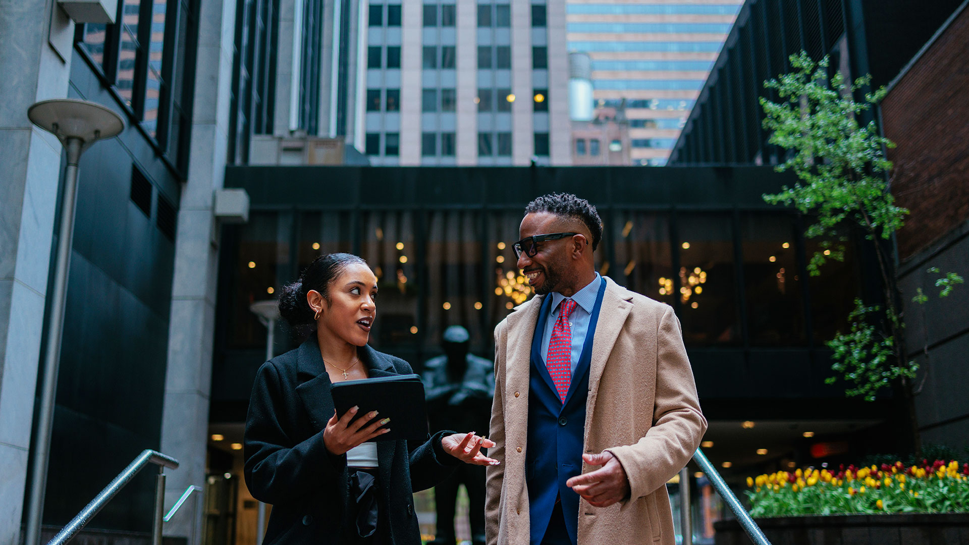 Two colleagues engage in a discussion outside an office on strategies to enhance customer experience in contact centers through omnichannel CX.