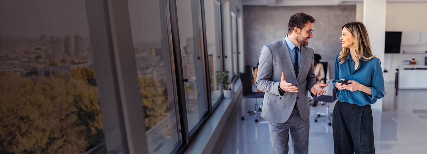 Two people in an office shaking hands after discussing wealth management solutions.