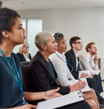 A group of people sitting in a room listening keenly